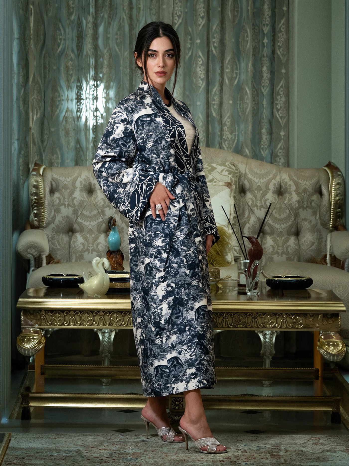 The coat belted, standing in the salon